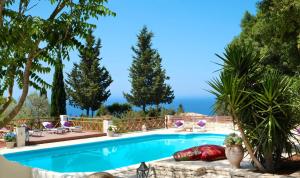 a swimming pool with a view of the ocean at Purple Apricot Hotel in Vlachopoulátika