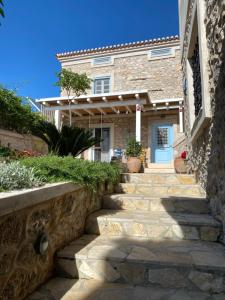 a stone path leading to a house with a blue door at Kranidi House. in Kranidi