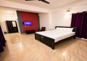 a bedroom with a bed and a tv in it at Courtyard Residency Thekkady in Thekkady