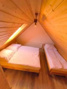 a bedroom with two beds in a wooden attic at Przystanek Borucino in Borucino