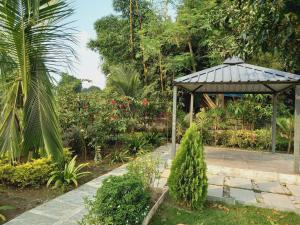 a garden with a gazebo in the middle at Aadarsh villa in Daulatābād