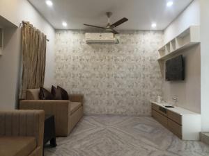 a living room with a couch and a tv at Aadarsh villa in Daulatābād