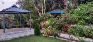 a garden with a gazebo and some plants at Aadarsh villa in Daulatābād
