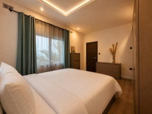 a bedroom with a white bed and a window at Spacious Townhouse - Private Jacuzzi -Swieqi in Is-Swieqi