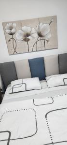 a bed with a picture of flowers on the wall at Casa Richiusa Calogero in Blufi