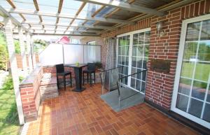 a patio with a table and chairs under a pergola at Ostseekoje Koje 5 in Süssau