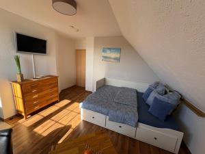 a small bedroom with a bed and a dresser at Ostseekoje Koje 6 in Süssau
