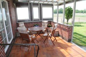 a screened in porch with a table and chairs at Ostseekoje Koje 6 in Süssau +7 photos