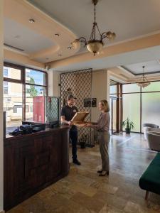 a man and a woman standing at a counter in a room at Alma by iVAVev Is'us in Mamaia