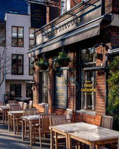 a group of tables and chairs outside of a restaurant at Three Falcons in London