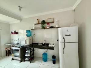 a kitchen with a white refrigerator and a counter at Grace Palace in Paraipaba