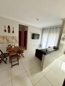 a living room with a table and a dining room at Grace Palace in Paraipaba