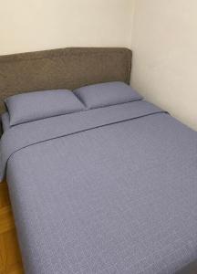 a bed with purple sheets and pillows in a room at Maca - vikendica sa bazenom in Ahatovići