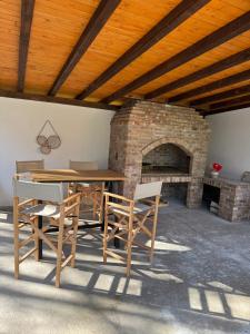 a wooden table and chairs and a brick fireplace at Maca - vikendica sa bazenom in Ahatovići