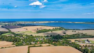 an aerial view of a farm and the ocean at Weiße Reetdachkate Wohnung 2 in Stöfs