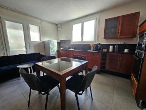 a living room with a table and chairs and a kitchen at Les Logis des Treize-Vents à 15 minutes du Puy duFou in Treize-Vents