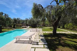a picnic table next to a swimming pool with a tree at Pilone del Monaco Apartment 9 in Vieste