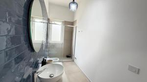 a bathroom with a sink and a mirror at Pilone del Monaco Apartment 9 in Vieste +8 photos