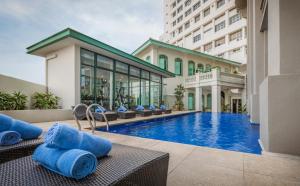 a swimming pool with chairs and a building at The Majestic Malacca, Melaka - Small Luxury Hotels of the World in Malacca