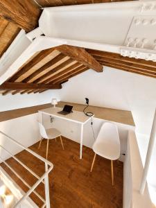 an attic office with a desk and two chairs at il "Terrazzino" nel cuore di Siena in Siena +15 photos