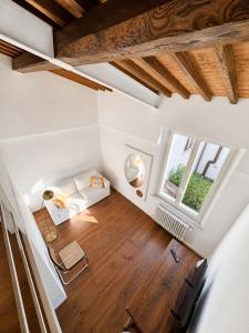 an attic room with a couch and two windows at il "Terrazzino" nel cuore di Siena in Siena