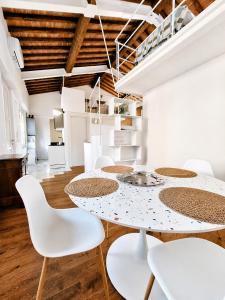 a white dining room with a white table and white chairs at il "Terrazzino" nel cuore di Siena in Siena
