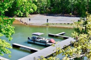 a boat parked at a dock on a river at Greystone - Cozy 2-bedroom Tiny Home in soothing Anderson SC on Lake Hartwell in Anderson