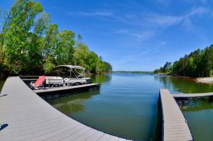 a dock with chairs and an umbrella on a lake at Greystone - Cozy 2-bedroom Tiny Home in soothing Anderson SC on Lake Hartwell in Anderson