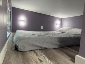 a large bed in a bedroom with purple walls at Greystone - Cozy 2-bedroom Tiny Home in soothing Anderson SC on Lake Hartwell in Anderson +21 photos
