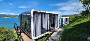 a row of mobile homes on a hill next to the water at Lake Capsule in Horizonte +3 photos