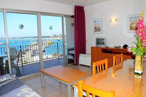 a living room with a dining room table and a balcony at Nautic 3-3 in L'Estartit