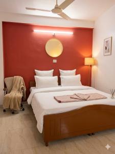 a bedroom with a large bed with a red wall at NG House in Indore +18 photos