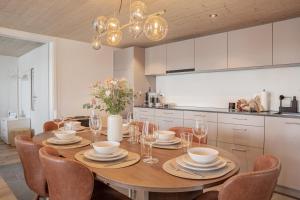 a dining room with a table and chairs and a kitchen at Casa Lago in Tüscherz-Alfermée
