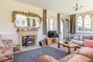 a living room with a fireplace and a tv at 4 Bed in Bridport oc-58847 in Powerstock