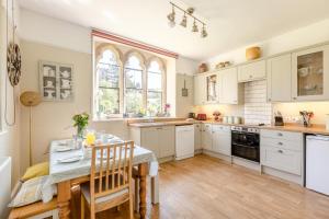 a kitchen with white cabinets and a table with chairs at 4 Bed in Bridport oc-58847 in Powerstock