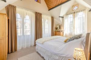 a bedroom with a large white bed and windows at 4 Bed in Bridport oc-58847 in Powerstock