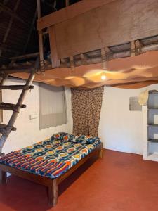 a bed in a room with a bunk bed at Rootscape Huts Hostel and Home Stay in Auroville