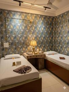 a room with two beds and a table with a lamp at NG House in Indore