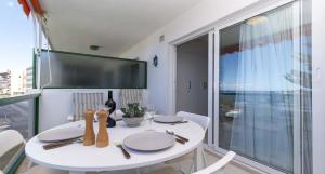 a white dining room with a white table and a window at Ocean View 3 in Los Cristianos