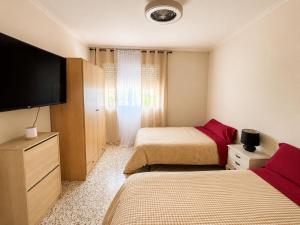 a bedroom with two beds and a flat screen tv at Casa Verna Jacuzzi y Barbacoa in Murcia