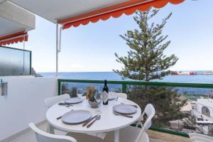 a white table and chairs with a view of the ocean at Ocean View 3 in Los Cristianos