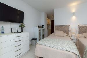 a bedroom with a bed and a dresser with a tv at Ocean View 3 in Los Cristianos +5 photos