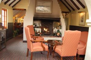 a living room with a table and chairs and a fireplace at Fourways Inn in Chelston