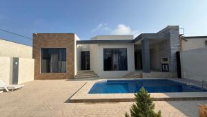 a house with a swimming pool in front of it at ReVaN in Baku
