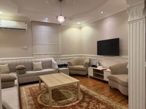 a living room with a couch and a tv at نزل العقيق بحي الجامعة in Medina