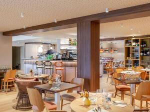 a restaurant with tables and chairs and a bar at ibis Styles Saint-Jean-de-Luz Donibane in Saint-Jean-de-Luz