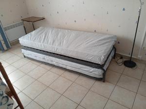 a bed with a white sheet on a room at studio 2 pers Fromentine centre in La Barre-de-Monts