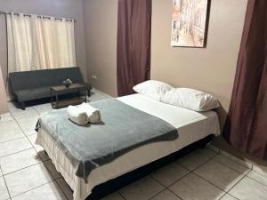a bedroom with a bed and a couch at Espacio Hermes Tu Rincón Céntrico in Comayagua