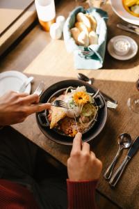 a person sitting at a table with a plate of food at Gîte du Mont-Albert - Sepaq in La Martre +145 photos
