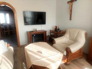 a living room with two chairs and a tv at Apartament na Libelta in Wągrowiec